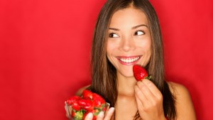 mujer-sonriendo-comiendo-fresa