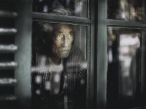 anciano-mirando-a-traves-de-la-ventana