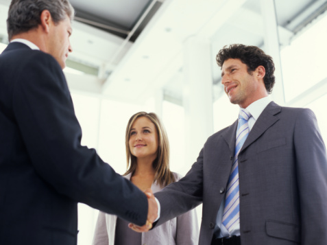 Businessmen shaking hands, low angle