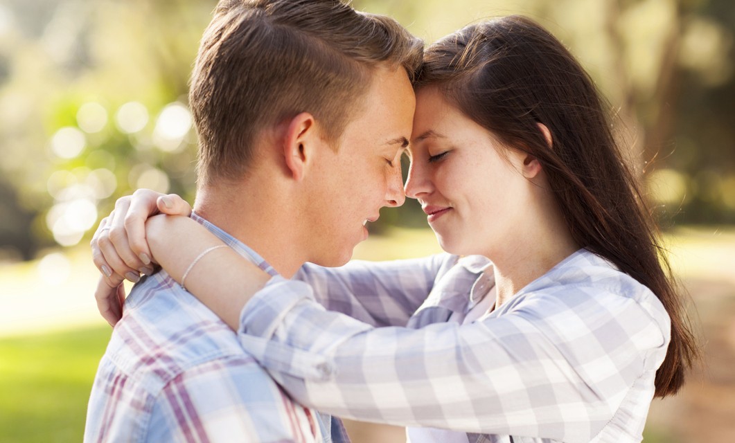 young teenage couple hugging with eyes closed