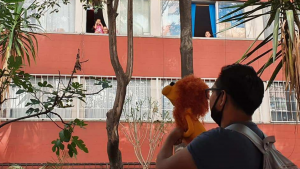Joven camina diario para leer cuentos a los niños desde sus ventanas