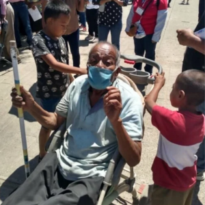 Pequeños llevan a su abuelito en carriola para que reciba su vacuna