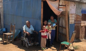 Pequeños llevan a su abuelito en carriola para que reciba su vacuna