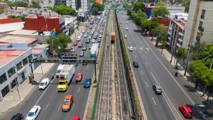 Aerial view of Tlalpan Avenue with an elevated train track in the middle, and the southern Mexico City skyline - Mexico City, Mexico