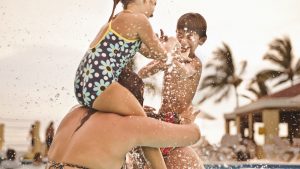 Happy family playing together in swimming pool