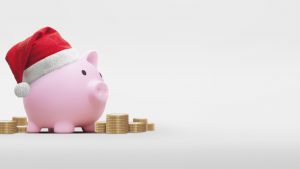 Pink piggy bank with santa claus hat on a white background - saving concept for christmas