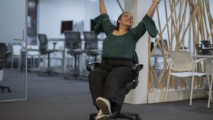 Happy successful office worker spinning around in a chair