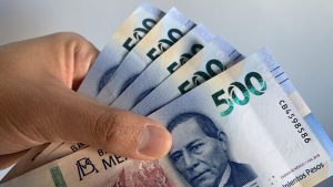 Hand holding mexican banknotes