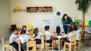 Teacher talking to students in the classroom at school