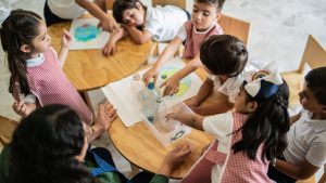 Teacher talking to students about recycling in the classroom at school