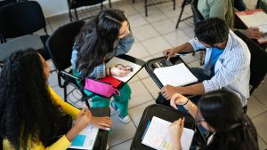 Circle of young friends studying together in the classroom at university