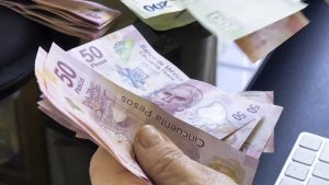 Senior woman counting money, Mexican pesos