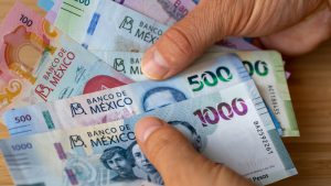 Mexico, Bundle of pesos banknotes held in hands, Financial concept, Mexican business success
