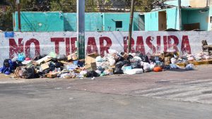 Close up of Garbage dump near the coastal avenue a fence that says do not litter