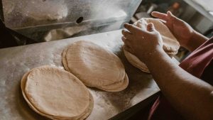 A Person Stacks Fresh Tortillas