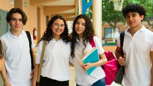 High school students wearing uniform posing in school hallway