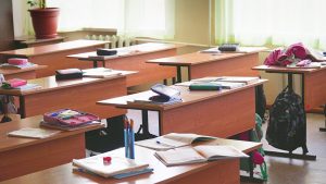 Empty classroom with textbooks, pencils on its desks