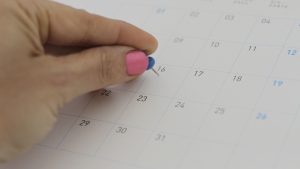 Close-up of woman hand pinning on Calendar Folder
