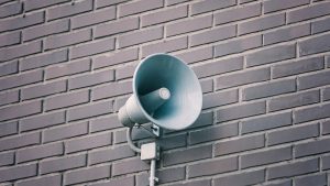 Loud speaker on brick wall.