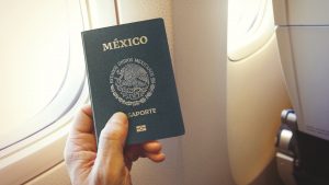 Passenger holding Mexican passport on the airplane