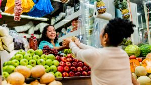 Mature saleswoman talking to customer at market