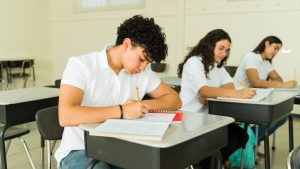 Latin high school students taking notes in class wearing uniform