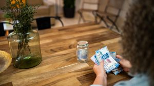 Close-up of woman counting Mexican pesos at home