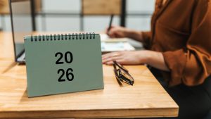 Cropped shot of businesswoman working at office desk with table calendar for new year