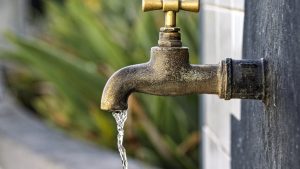 Drinking water faucet slowly dripping water into the open air.