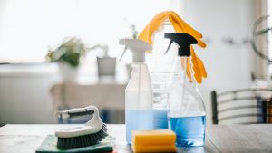 collection of cleaning supplies on surface of the kitchen table