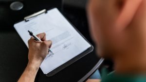Close-up of a man signing a contract