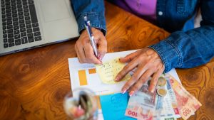 Woman doing home finances and counting money at home