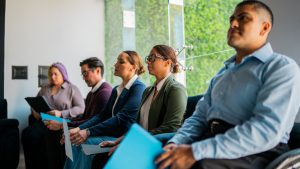 Group of people waiting for job interview in the waiting room at office