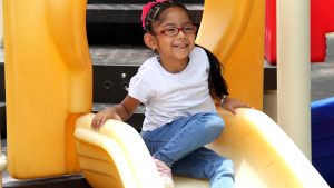 Brunette latin woman girl with glasses plays outdoors in free games, happy, doing physical activity