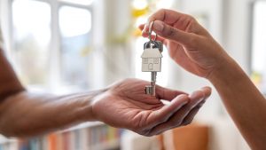 Real estate agent giving the keys of a new house to a man