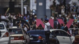 A transit police officer is letting cars pass on the road