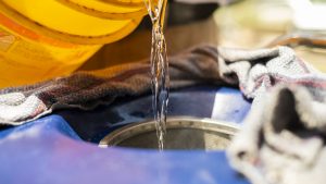 Cleaning solution being poured onto an industrial vacuum cleaner