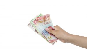 Outstretched hand holding banknotes, making the gesture of paying, with white background and copy space