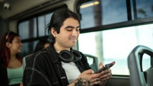 Young man using a mobile phone on a bus