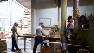 Warehouse workers using a saw cutting wooden planks - industrial district in Mexico City, Mexico