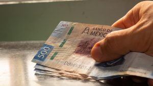 hand holding mexican money called pesos