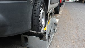 Wheel immobilizer device used by police and traffic officers to immobilize motor vehicles that have violated laws