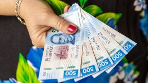 Mexico money. 500 peso paper bills in a woman's hand. Financial business concept. Investment background