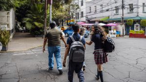 Rear view of family crossing street in Mexico City