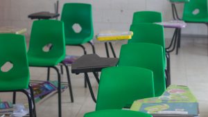 Empty school classroom with green student desks