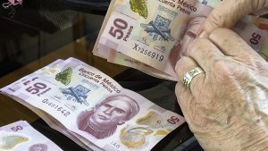 Senior woman counting money, Mexican pesos