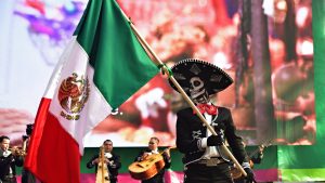 Dia de los Muertos carnival. Sugar skull makeup man with flag