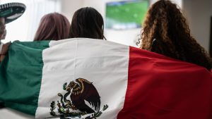 Rear view of friends watching Mexican soccer team play at home