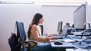 Young woman architect working on computer in office